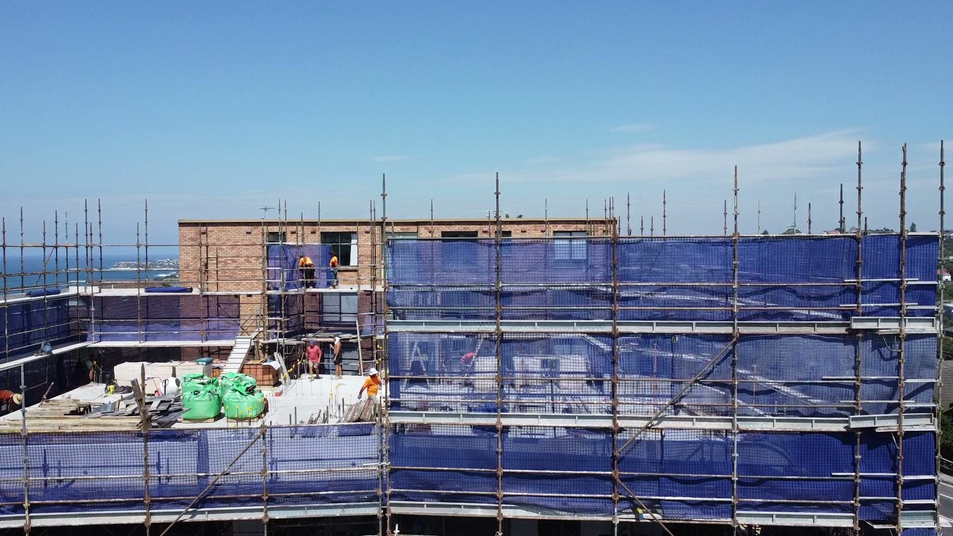 Ozscaf crew working on the top lift of the Coogee scaffold, ocean in the background