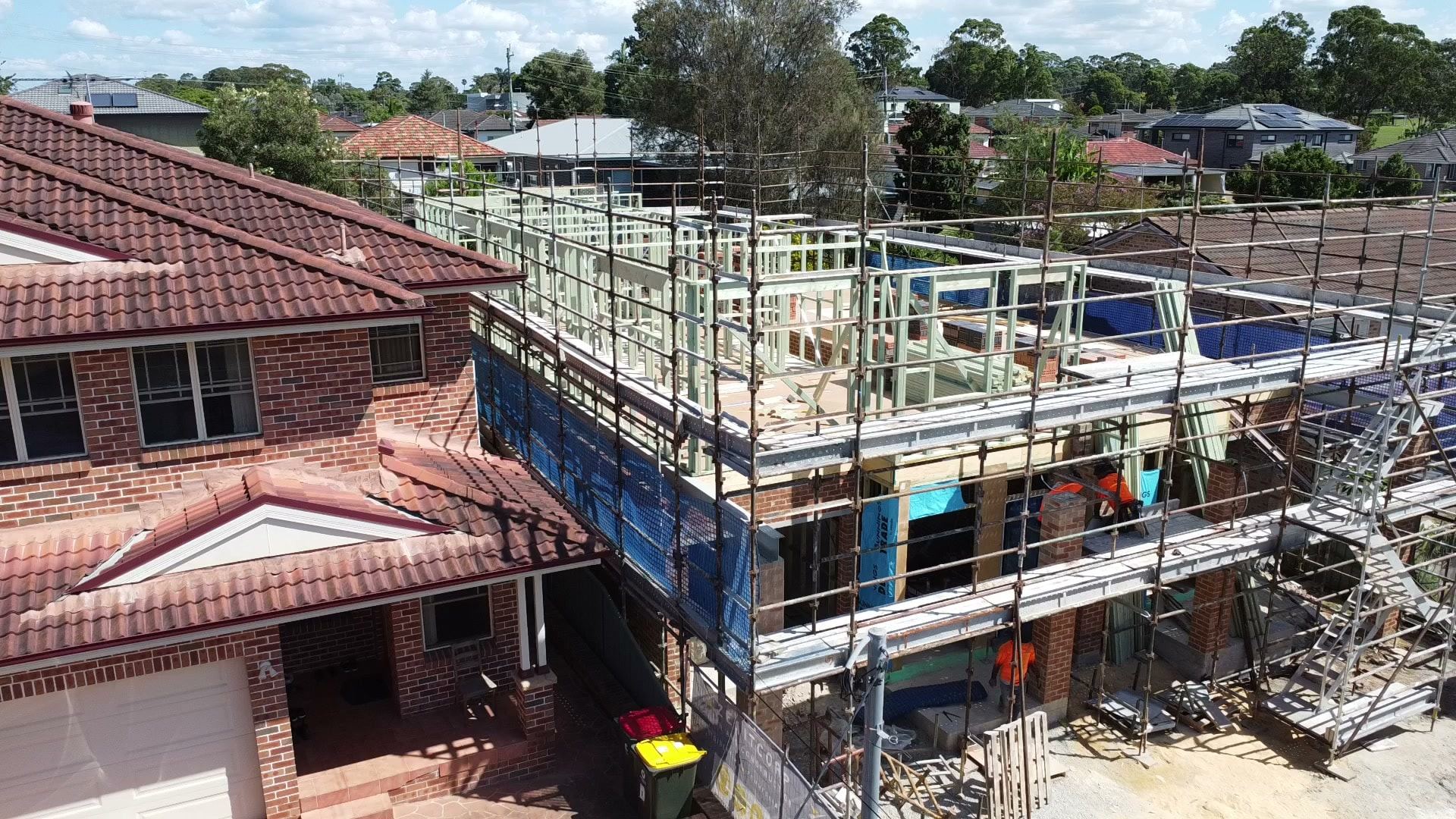 Aerial view along the scaffolded duplex with the frame going up