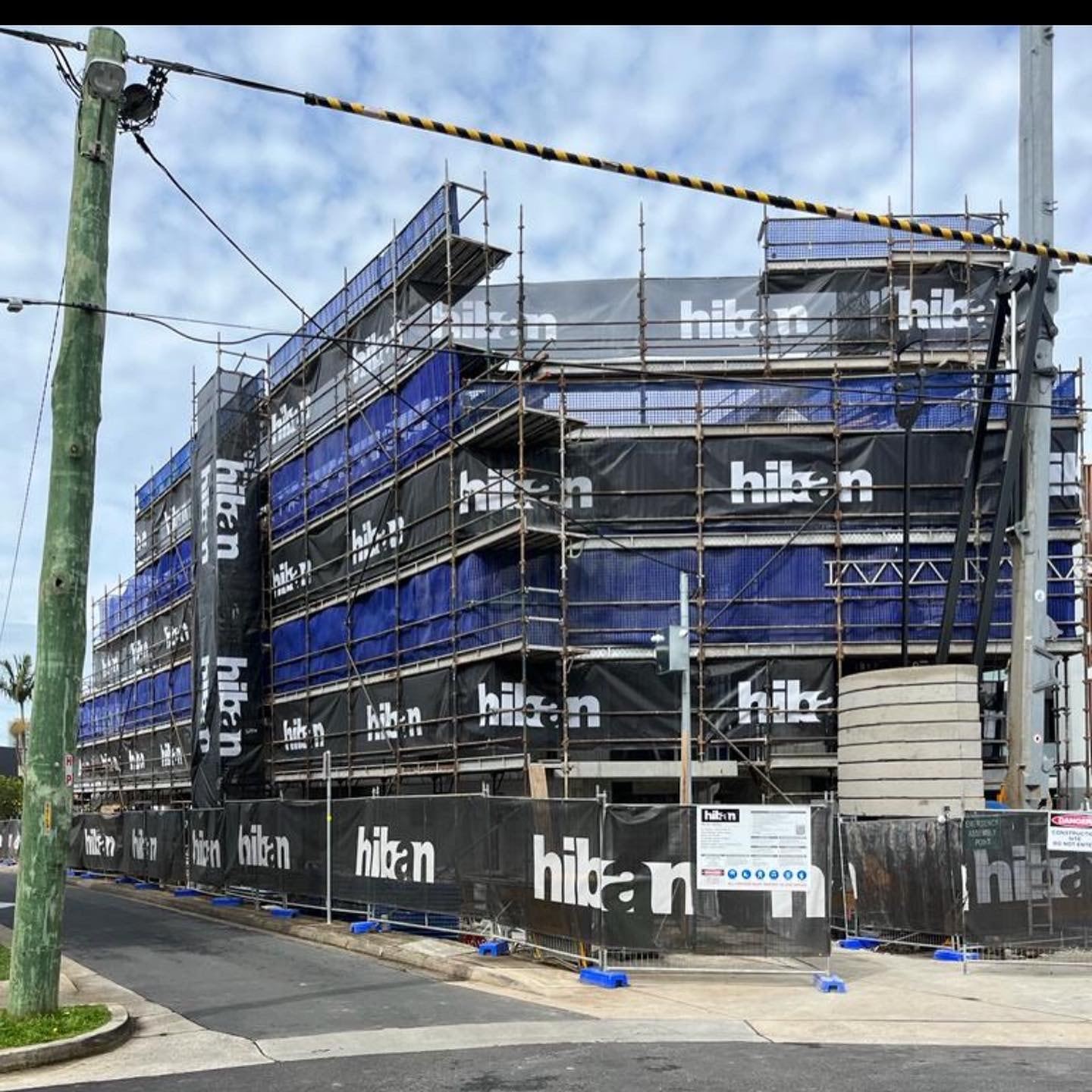Commercial building wrapped in blue scaffold mesh
