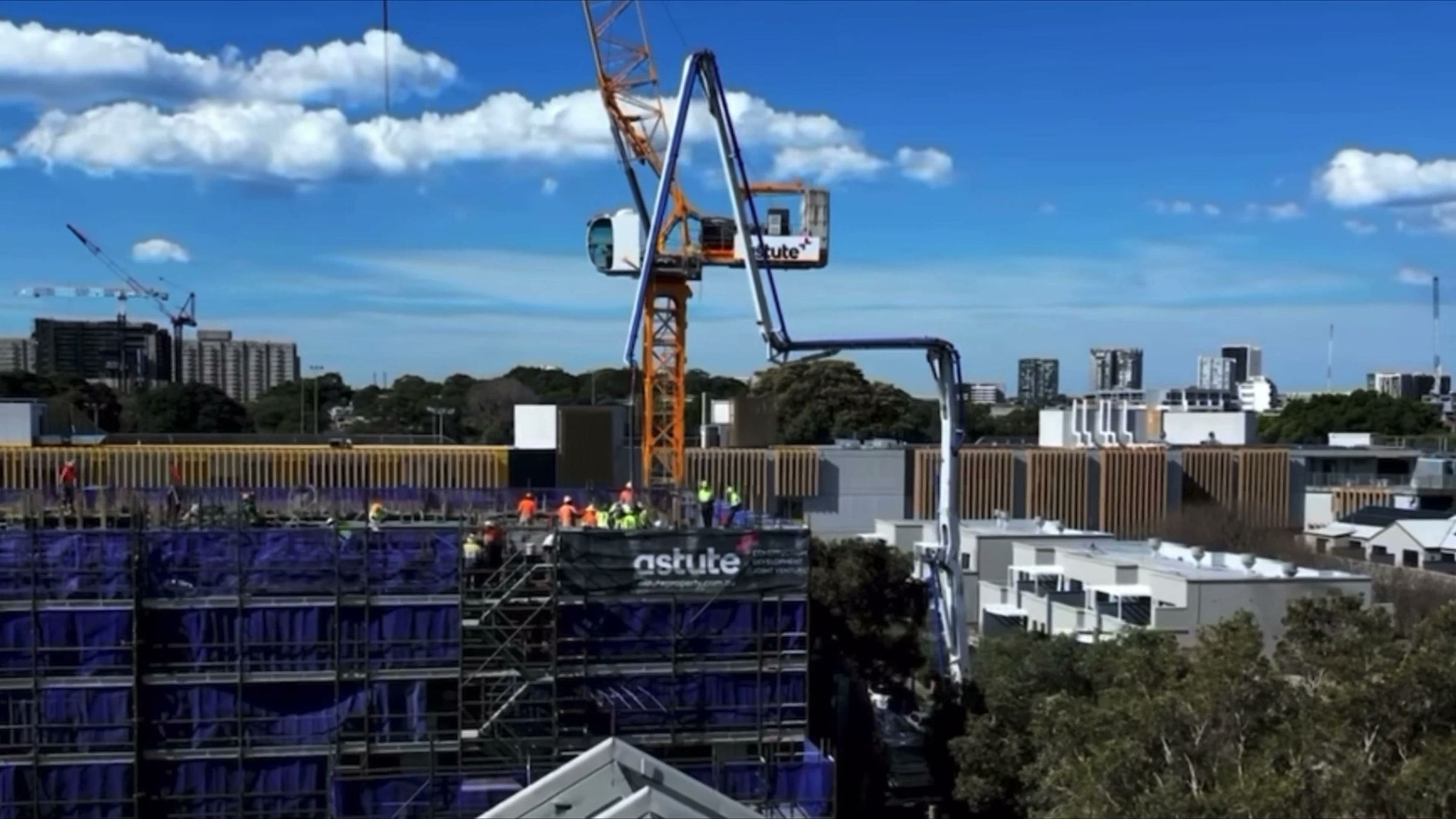 Ozscaf crew working on the top lift of a commercial scaffold beside a tower crane