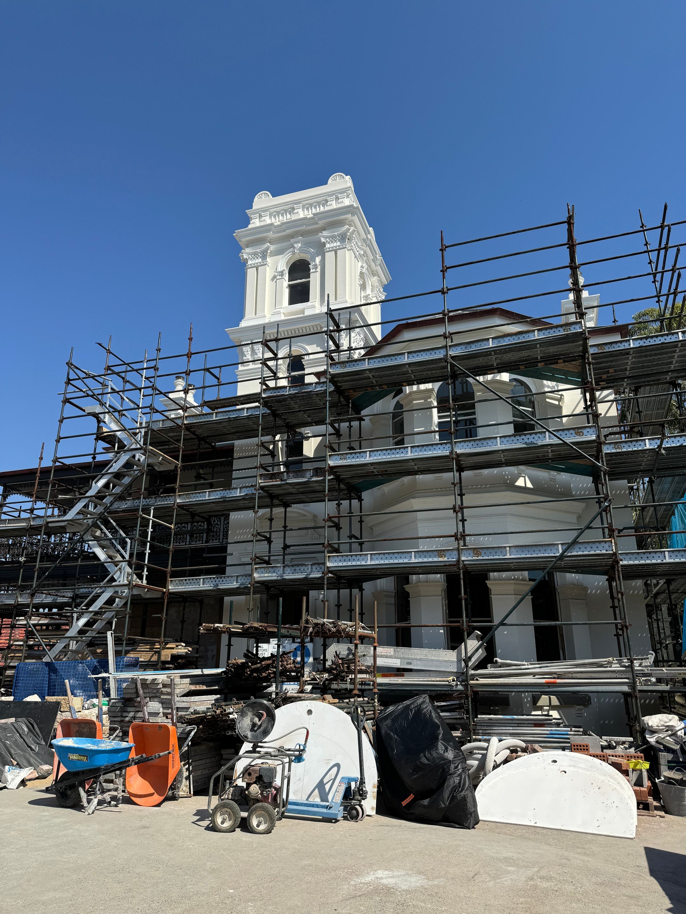 Scaffold around a heritage building with a white tower