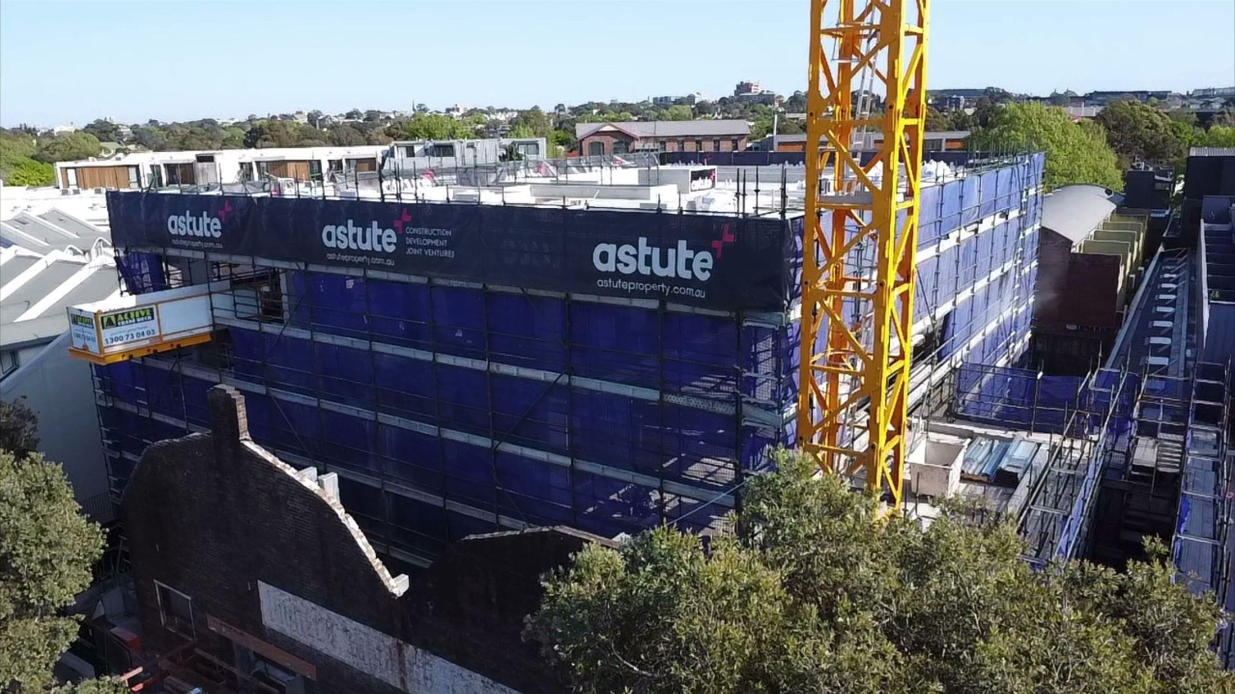 Aerial view of the Alexandria development wrapped in Ozscaf scaffold, tower crane alongside