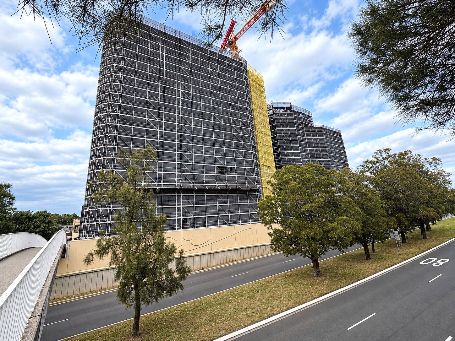 The Centennial Collection, Bondi Junction: two towers fully wrapped in Ozscaf scaffold, tower crane above