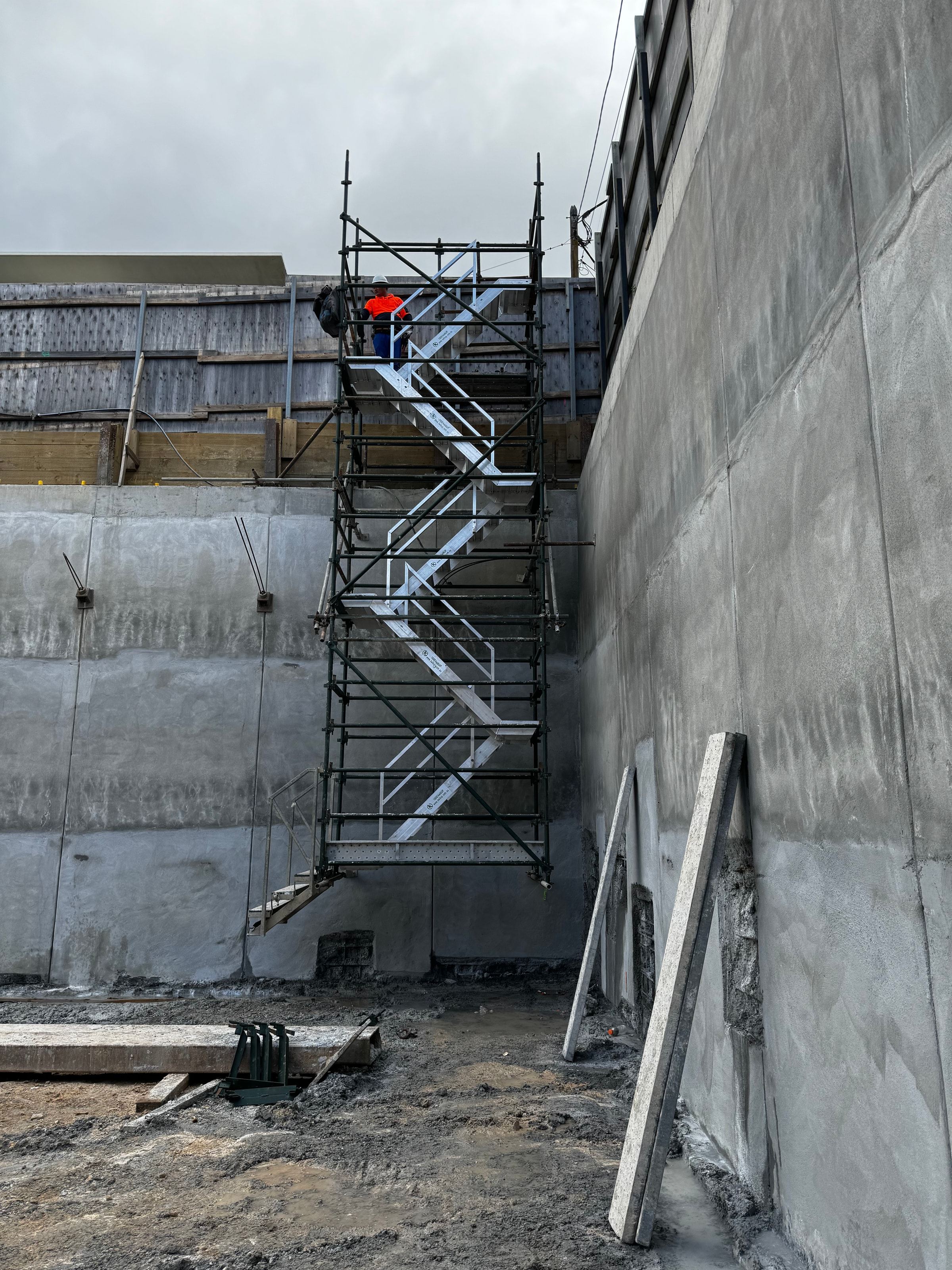 Hung stair tower giving access into the basement excavation at Chiswick, scaffolder at the top