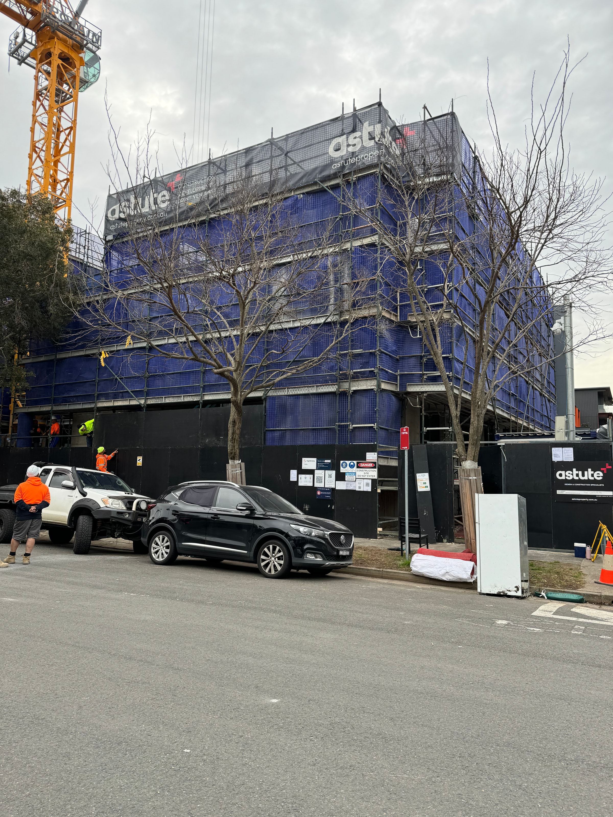 Ozscaf crew at the base of a commercial scaffold in Alexandria, tower crane overhead